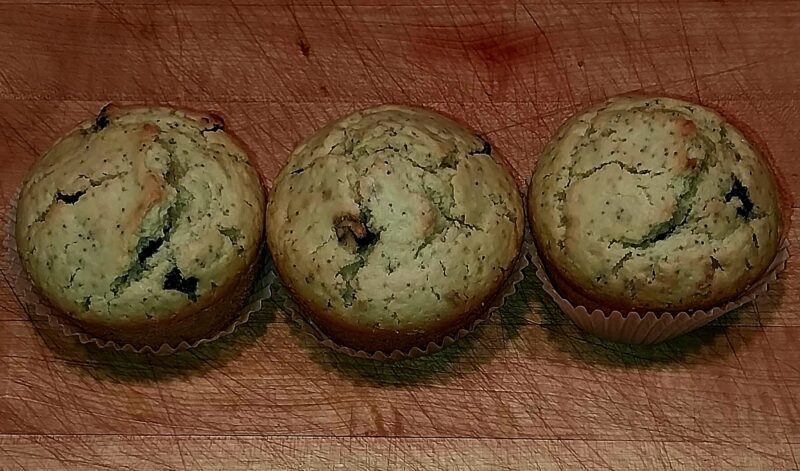 Three blueberry, lemon and poppy seed muffins fresh from the oven.