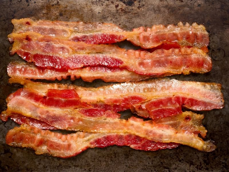 strips of bacon cooking on a hot griddle