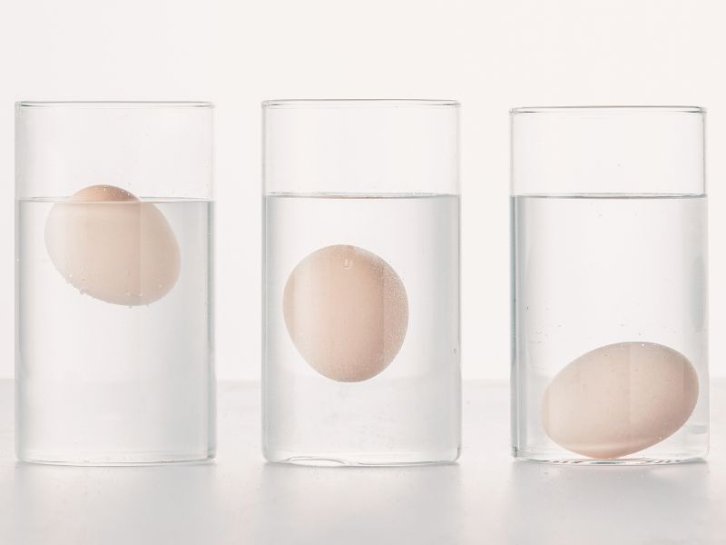 3 eggs floating in 3 glasses of water for a freshness test