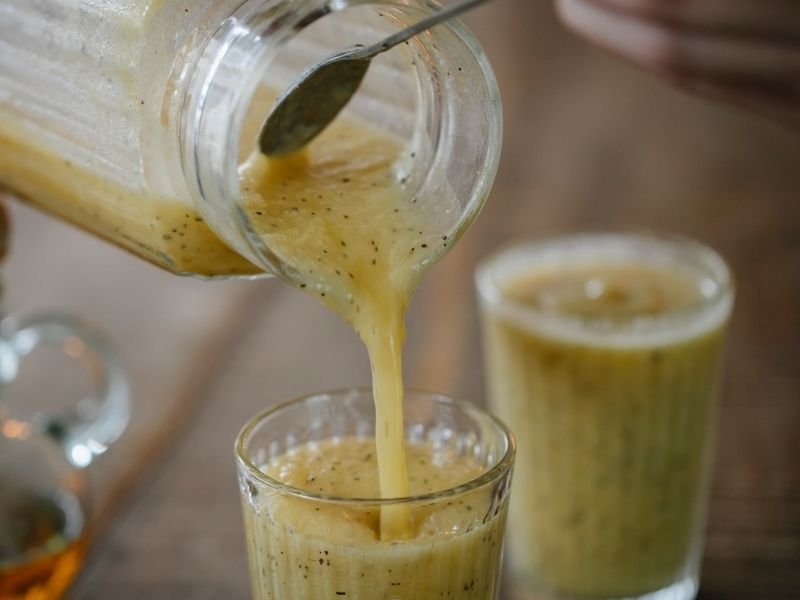 delicious banana smoothie being poured into glasses