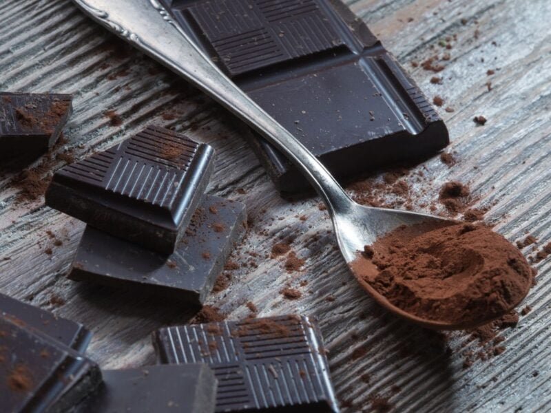pieces of healthy dark chocolate and dark chocolate powder in a spoon