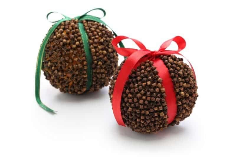 two handcrafted pomander balls with red and green ribbons