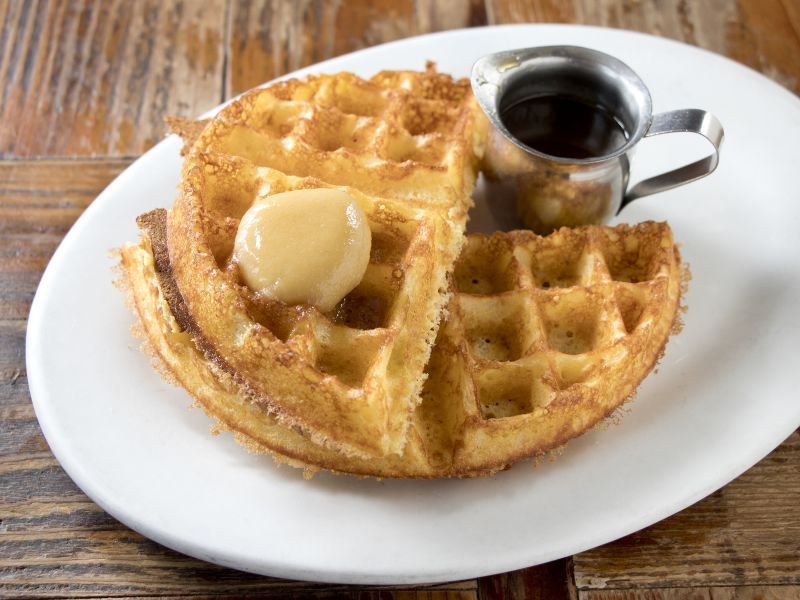 A large dollop of honey butter on hot waffles