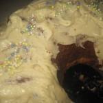 a freshly baked cake with vanilla frosting and natural sprinkle decorations