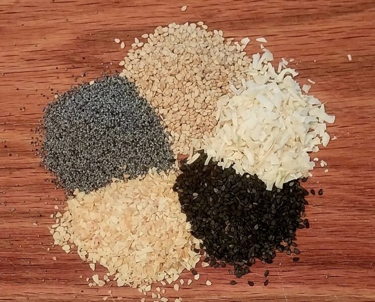 Ingredients in little piles on a cutting board for Everything Bagel Seasoning Mix