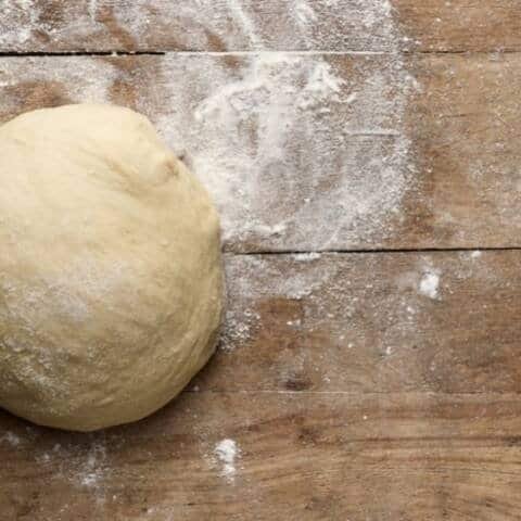 Fresh homemade pizza dough ready for baking.