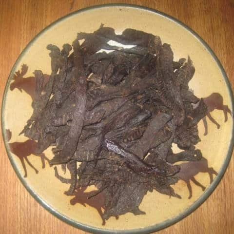Homemade Wild Game Jerky on a tan ceramic platter