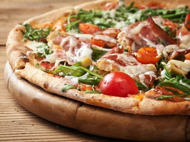 Delicious homemade pizza topped with fresh vegetables, meats, and melted cheese, perfect for a cozy.