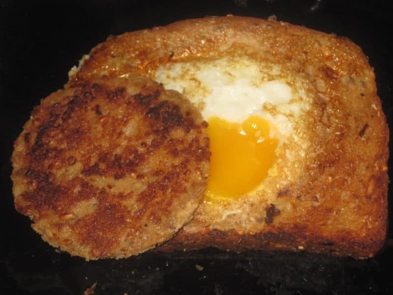 close up of egg in a hole breakfast treat with one egg cooked in a hole in a slice of bread