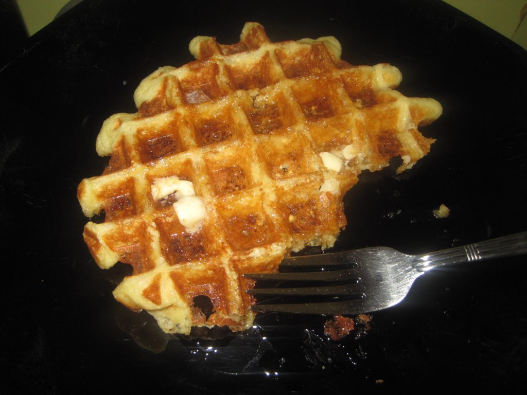 Einkorn Waffles on a black plate with a fork