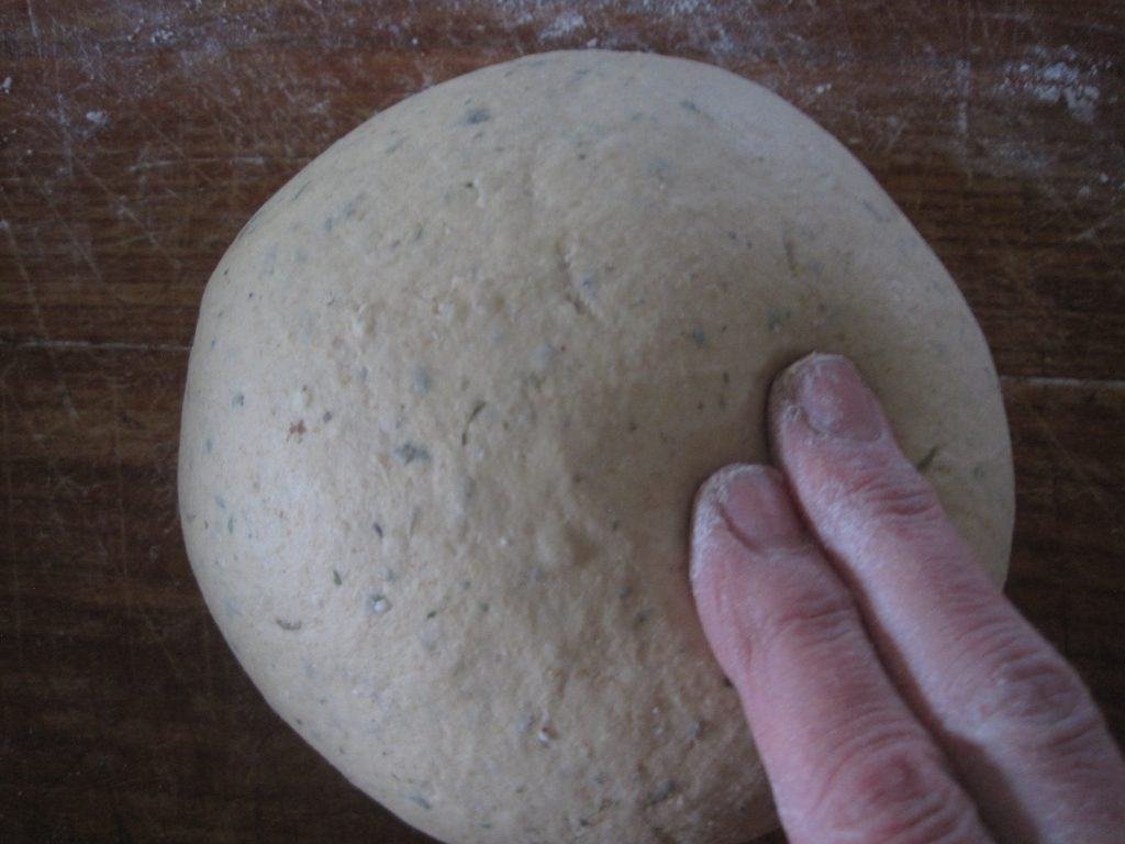 a baker testing in their bread dough has risen enough