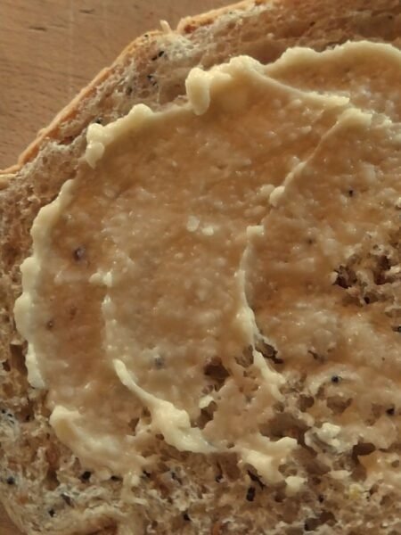 Maple syrup butter spread on whole grain toast, creamy and rich.