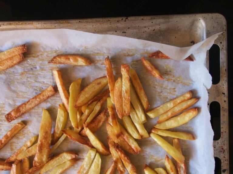 Oven baked fries on white parchement paper