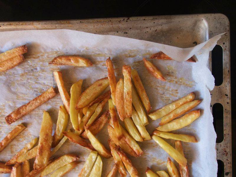 Oven baked fries on white parchement paper