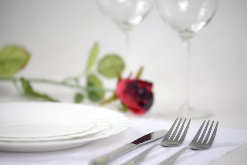 Simple Rose at a table Setting with white china dishes