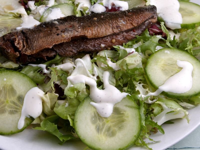 a dinner plate of steak slices and salad with ranch