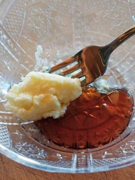 Creamy maple syrup butter in a glass bowl with a fork, ready to serve.