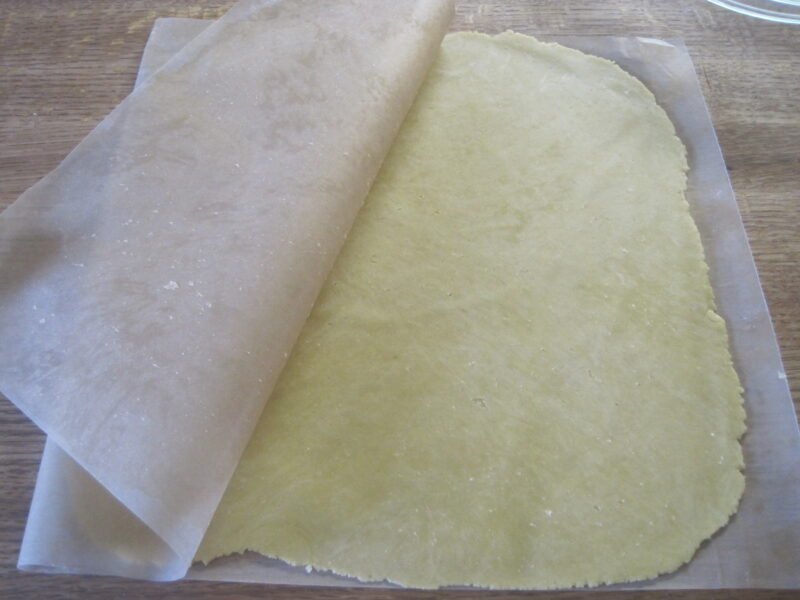 Freshly rolled homemade pie crust on parchment paper for baking.