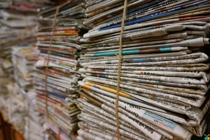 stacks of old newspapers that can be used for mulch in garden rows